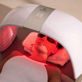 Person reclining beneath LumaLux Dome with red light illuminating the face
