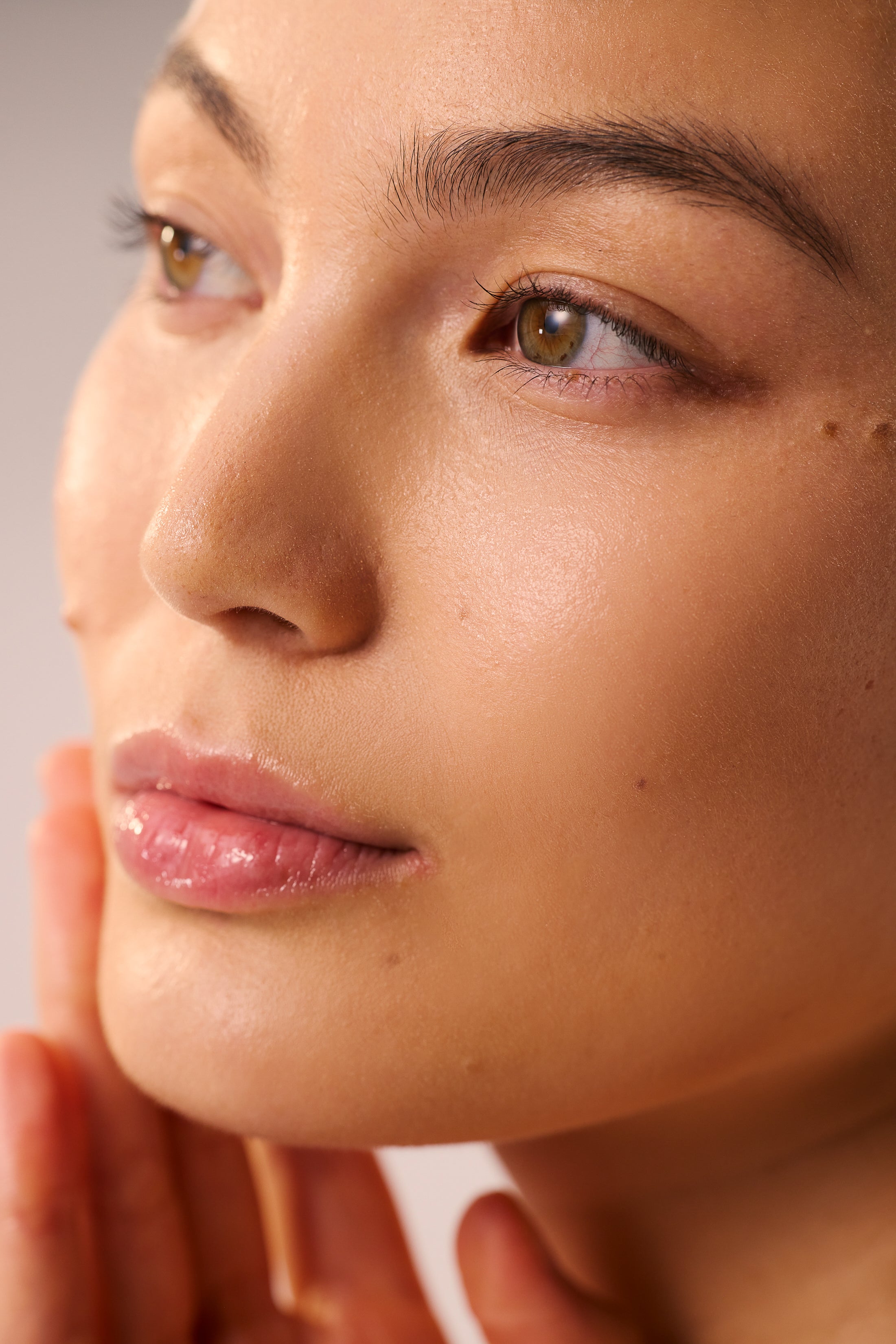 Woman showing clear radiant skin results after LED light therapy treatment.